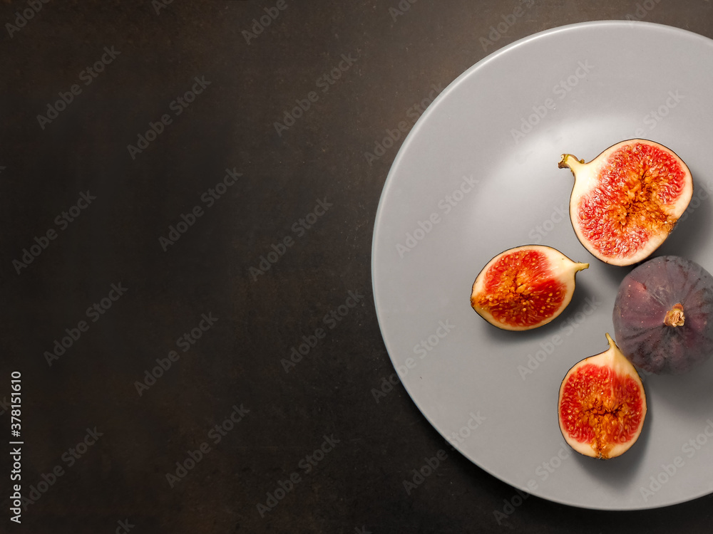 Fresh ripe whole and sliced figs on a black background. Fresh ripe whole and sliced figs on a black background.