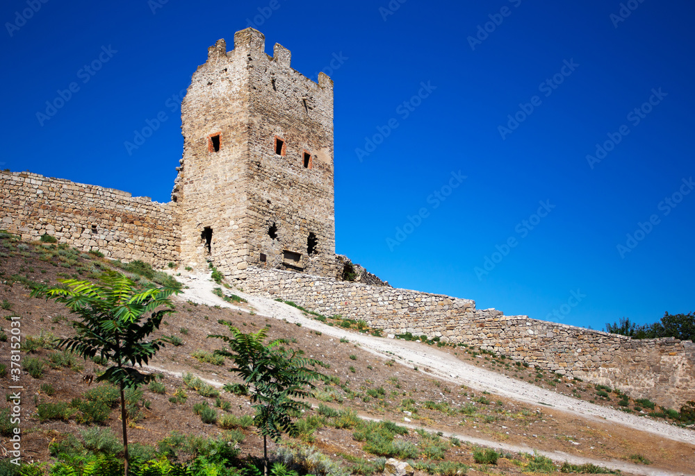 Ancient historic Genoese stone castle or fortress against the blue sky in Crimean peninsula. The place of interest in Crimea