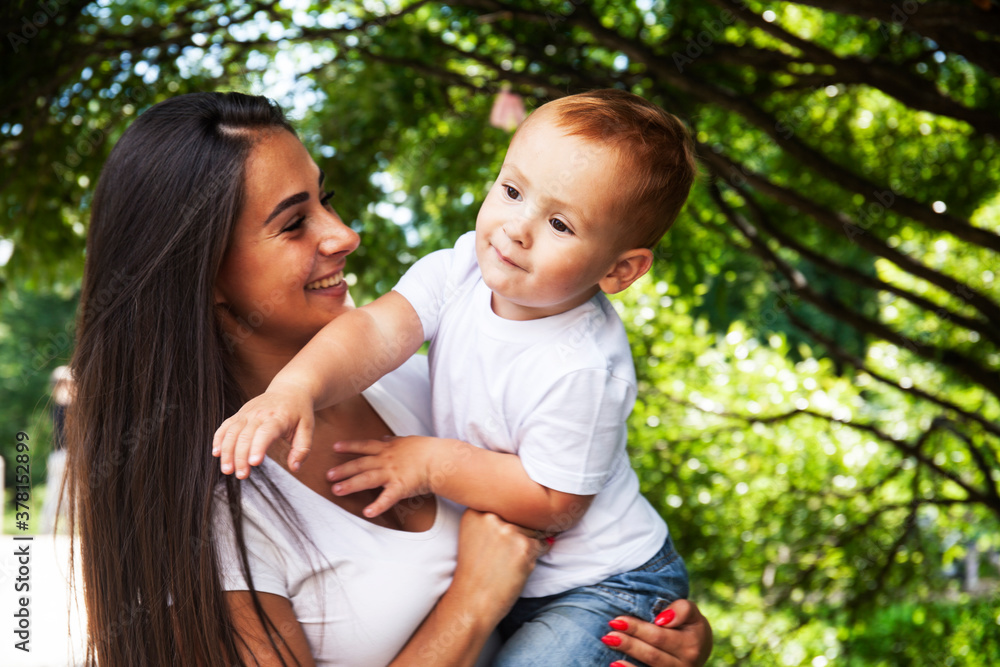 young pretty brunette mother with little cute boy walking in park happy smiling, lifestyle people concept young pretty brunette mother with little cute boy walking in park happy smiling, lifestyle people concept