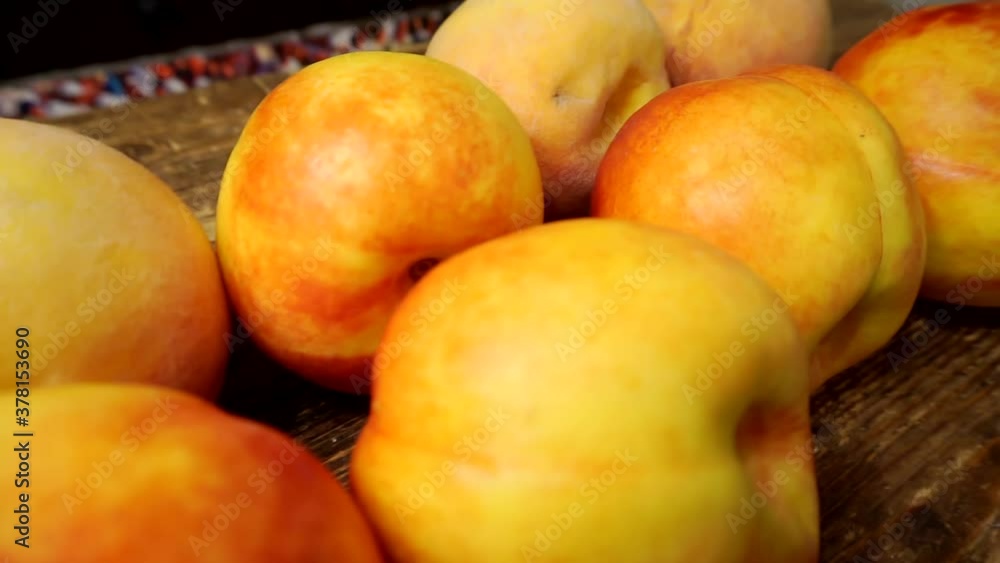 ripe juicy bright peaches and nectarines lie on a wooden table. ripe juicy bright peaches and nectarines lie on a wooden table.