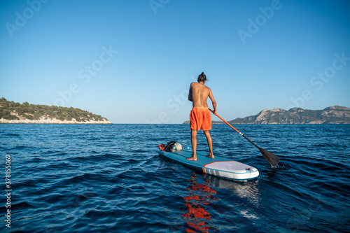 Young spanish man using his SUP on an idyllic place in Formentor, Mallorca (Spain) during a sunny day © Daniel