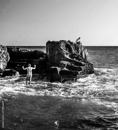 Niño subido a una roca en la playa