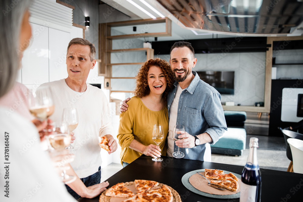 Happy couple is posing at camera and holding wine Happy couple is posing at camera and holding wine