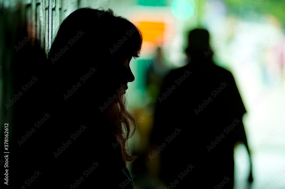 Mysterious silhouette of a teenage girl in a street environment of street children Mysterious silhouette of a teenage girl in a street environment of street children