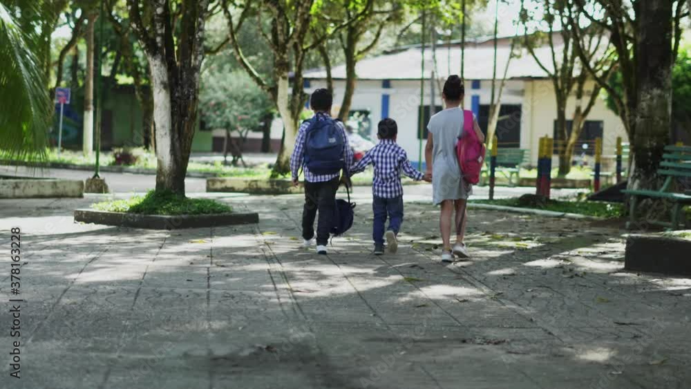 three children are walking with school bags three children are walking with school bags