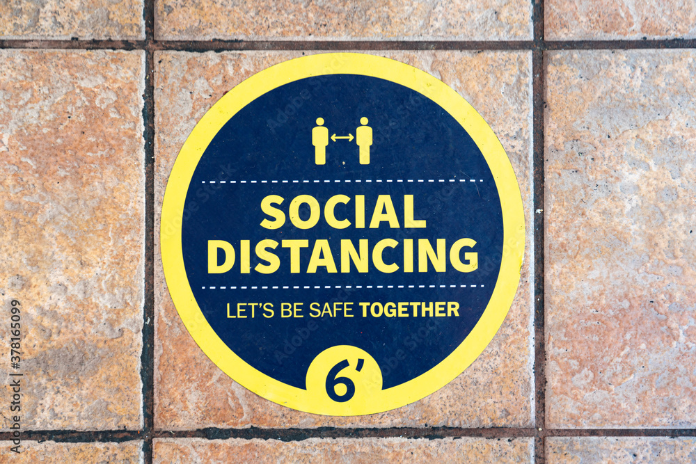 Circular sign on the ground encouraging social distancing Circular sign on the ground encouraging social distancing