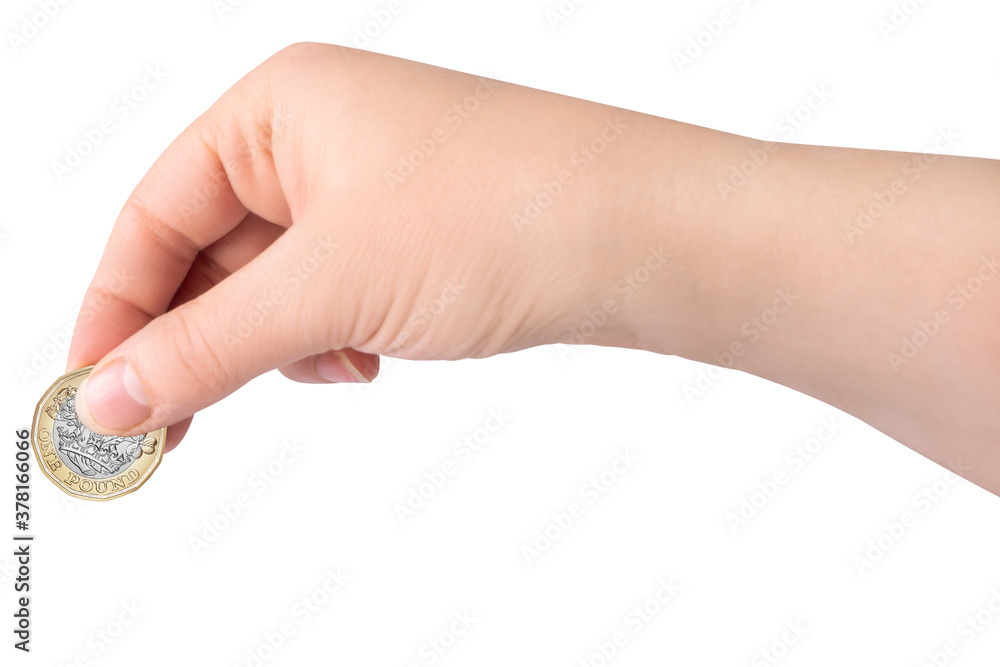 A female hand holding a one pound British coin on white background, isolated. A female hand holding a one pound British coin on white background, isolated.