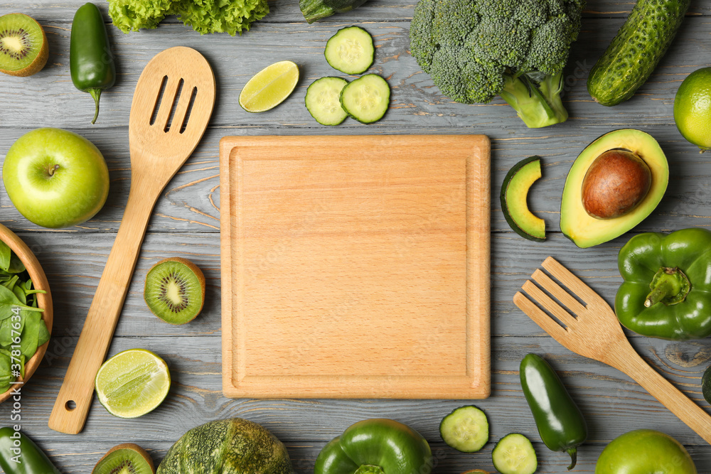 Board, fork, spoon, vegetables and fruits on wooden table Board, fork, spoon, vegetables and fruits on wooden table