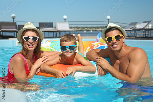 Happy family with inflatable ring in swimming pool © New Africa