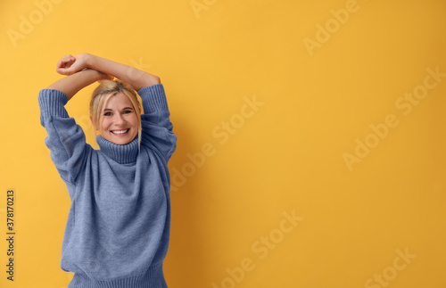 Happy woman in stylish sweater on yellow background. Space for text © New Africa