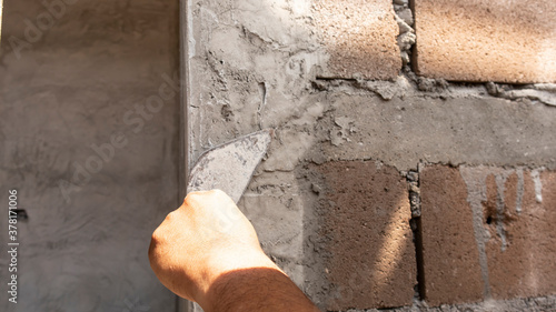 Tiler's hand.bricklayer plaster a wall inside a building