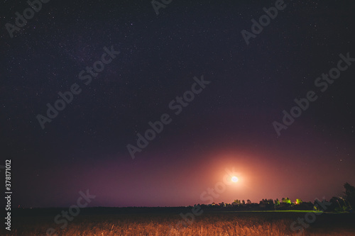 Moonrise Above Belarusian Village In Eastern Europe. Belarusian Countryside In Summer Starry Night © Grigory Bruev