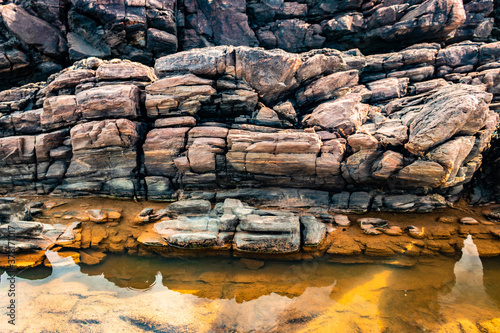 natural rock formation at senatural rock formation with water reflection at sea shore due to crashing waves at morninga shore due to crashing waves at morning photo