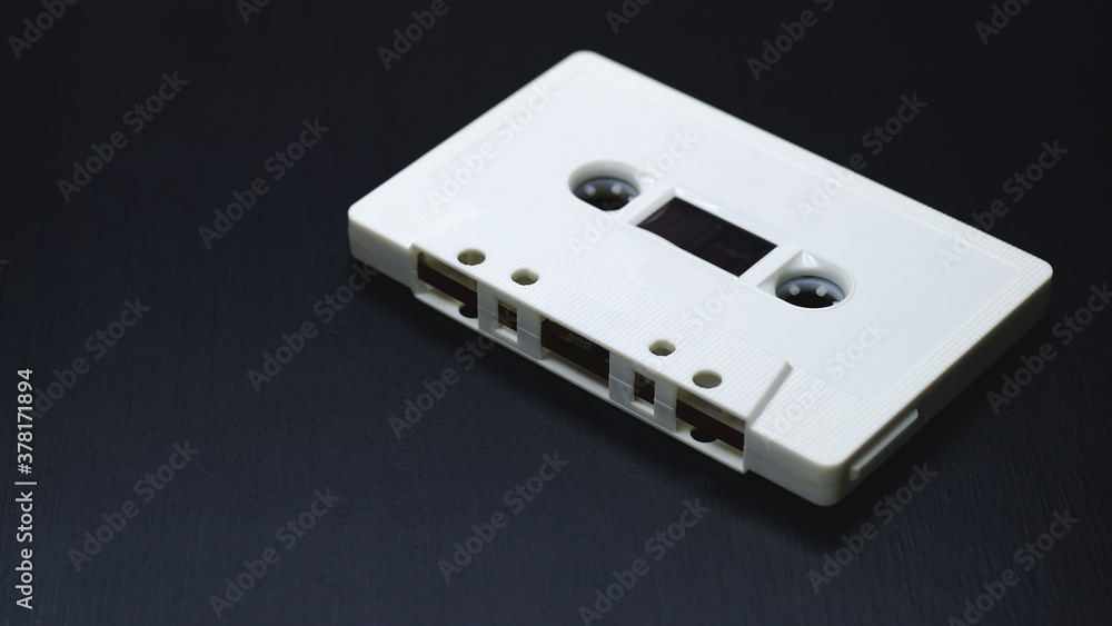 Old audio cassettes on dark wooden background.
Old audio cassettes on dark wooden background.