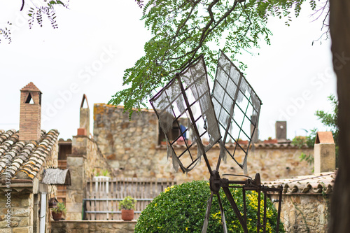 Old damaged wind mill on a medieval rural village town photo