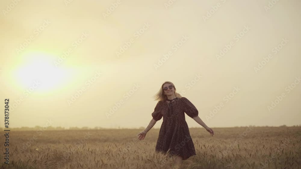 woman in animal print dress, straw hat in front of Sun in middle of wheat field with pleasure , enjoying summer holidays. woman in animal print dress, straw hat in front of Sun in middle of wheat field with pleasure , enjoying summer holidays.