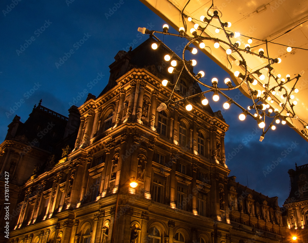 Christmas in Paris. Night view of illuminated Hotel de ville (city hall) building through Christmas lights decoration at Rivoli street.