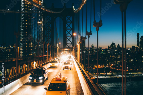 Vehicles with bright headlights driving on Manhattan bridge © BullRun