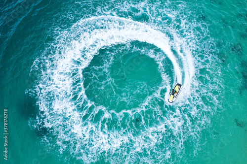 People are playing a jet ski in the sea.Aerial view. Top view.amazing nature background. The color of the water and beautifully bright. © MAGNIFIER