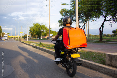 behing fast food delivery man on the road photo