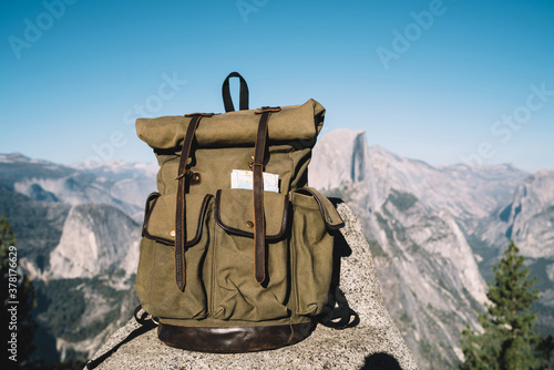 Touristic backpack on high cliff in mountains