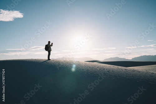 Anonymous man taking photo of sunset in White Sands National Park