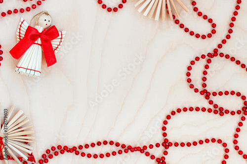 Christmas decoration with angel and red bow on wooden background
