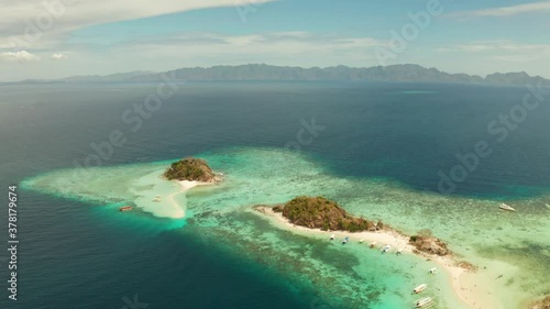 aerial seascape bay with tropical island and sand beach, turquoise water and coral reef. Bulog Dos, Philippines, Palawan. tourist boats on coast tropical island. photo