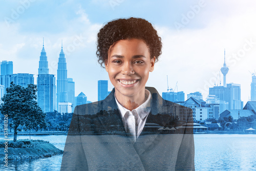 Successful smiling black African American business woman in suit. Kuala Lumpur cityscape. The concept of woman in business. KL skyscrapers. Double exposure. photo