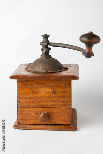Close-up of old wooden coffee grinder, with unfocused handle, on white background, in vertical with copy space