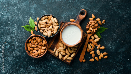 Bild auf Leinwand Almond milk and almonds on black stone background