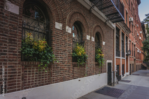 Fototapeta Naklejka Na Ścianę i Meble -  Brick wall facade of apartment building on residential block of East Village in Manhattan