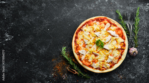 Traditional pizza with chicken, pineapple and corn. Top view. free space for your text. Rustic style.