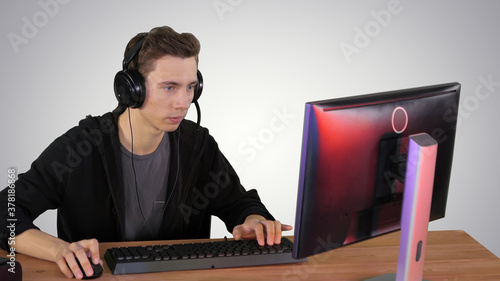 Concentrated angry brunette man playing video game on gradient b