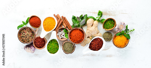 Fototapeta Naklejka Na Ścianę i Meble -  Various spices in a bowls on white background. Indian spices. Top view.