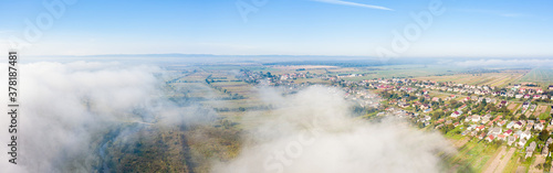 Aerial drone view of scenic countryside in autumn sunny and misty day. Birds eye view of traditional Ukrainian village © dero2084