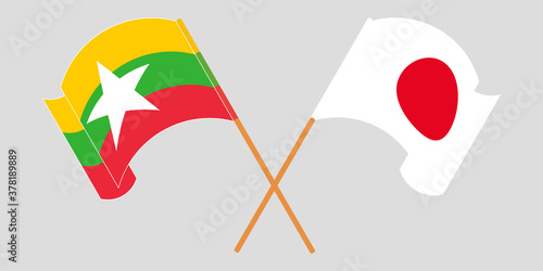Crossed and waving flags of Myanmar and Japan