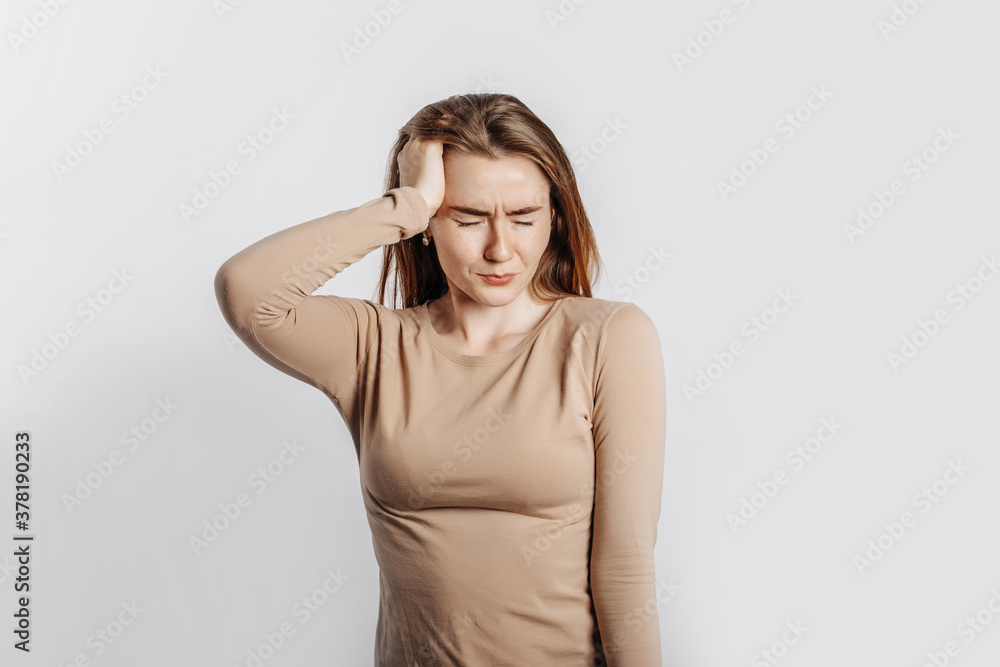 Beautiful young girl posing looking at the camera on a white isolated background. Serious brunette woman ignores covers her ears with her hands and closes her eyes, does not see and does not hear Beautiful young girl posing looking at the camera on a white isolated background. Serious brunette woman ignores covers her ears with her hands and closes her eyes, does not see and does not hear