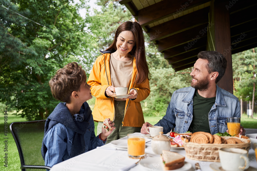 Adorable boy having breakfast with parents outdoors Adorable boy having breakfast with parents outdoors