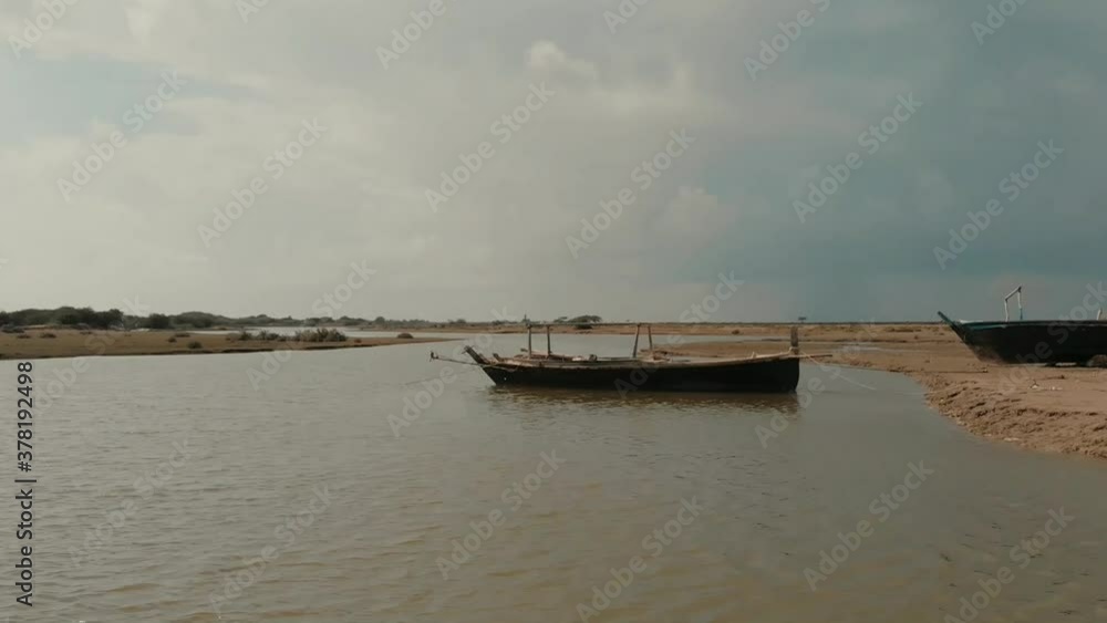 Aerial Dolly Back Of Wooden Boat Moored In River In Pakistan Aerial Dolly Back Of Wooden Boat Moored In River In Pakistan