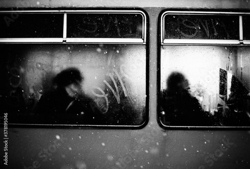 Greyscale shot of silhouettes of peope in a metro train photo