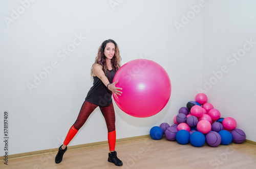 sport, training and lifestyle concept - beautiful woman with fitness ball in the gym.