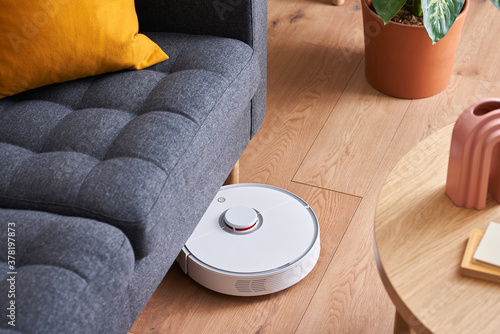 Robotic vacuum cleaner tidying under couch