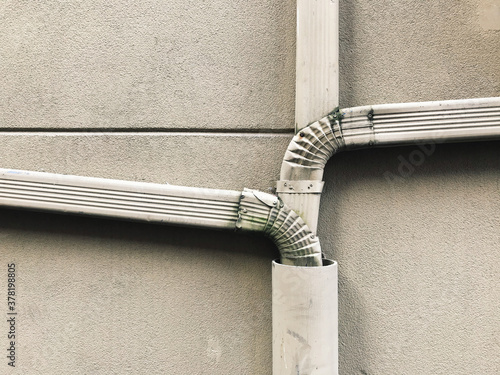 Old gutter and drain pipes on building wall, close up