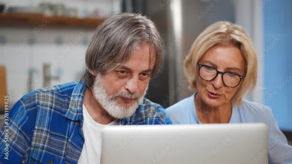 Senior Couple Using Laptop To Check Finances At Home Senior Couple Using Laptop To Check Finances At Home