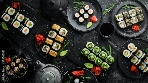 Set of traditional sushi on a black plate. Sushi and rolls on a dark background.