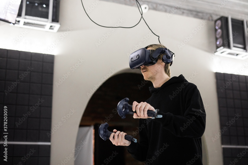 Man enjoying vr gaming in an indoor arcade Man enjoying vr gaming in an indoor arcade