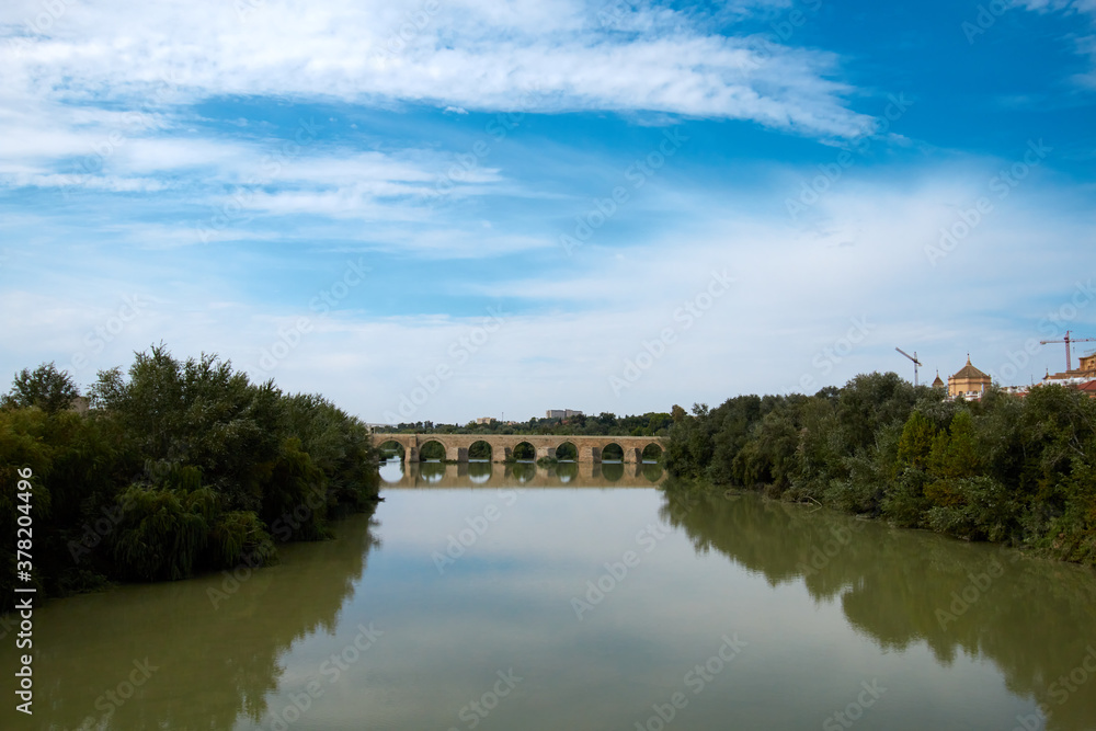 El viejo puente junto al río, con cielo nublado