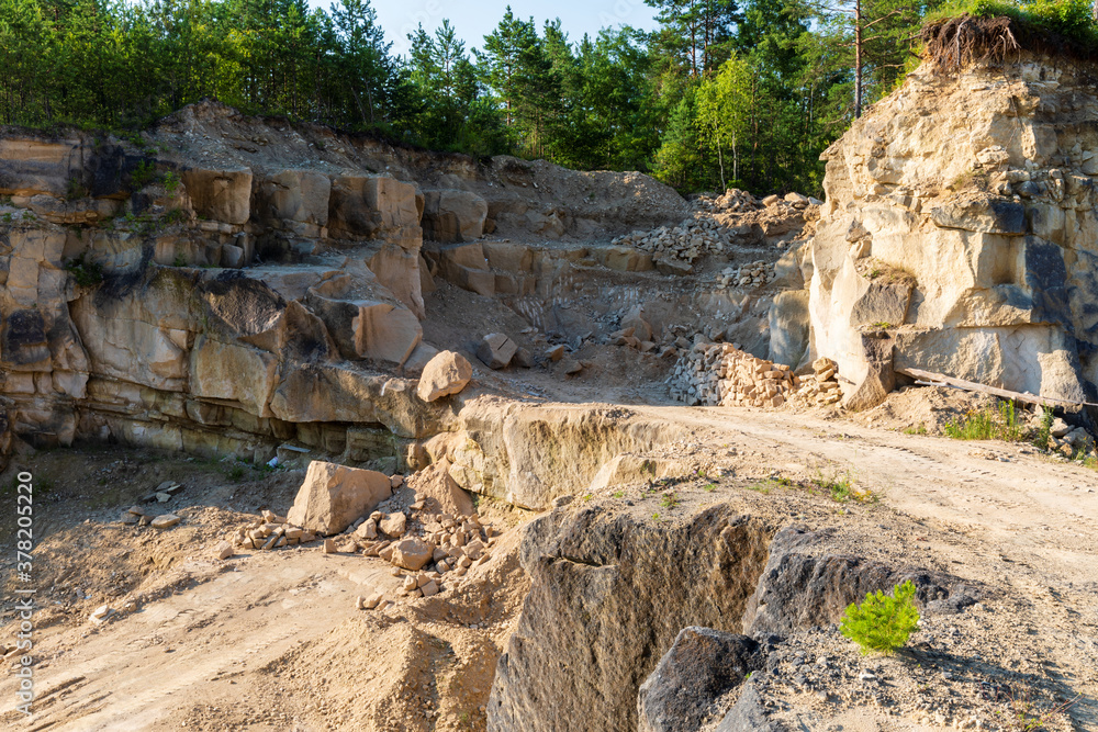 Big stones in limestone quarry. Hillside wall behind. Mine in Jozefow, Poland, Europe. Big stones in limestone quarry. Hillside wall behind. Mine in Jozefow, Poland, Europe.