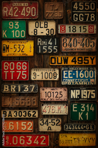 Various retro License Plates on the wooden wall. photo